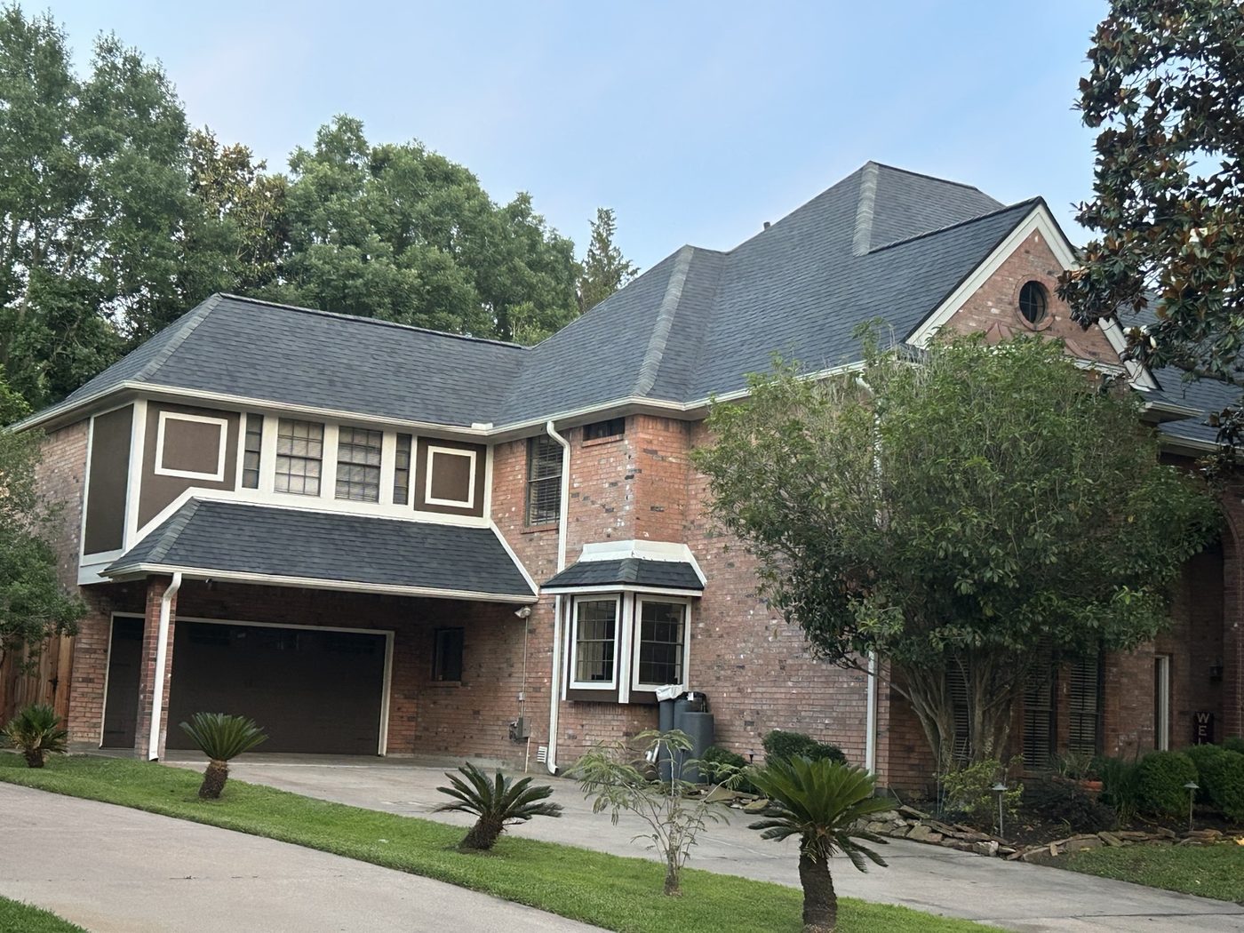 Two-story brick house with a shingle roof